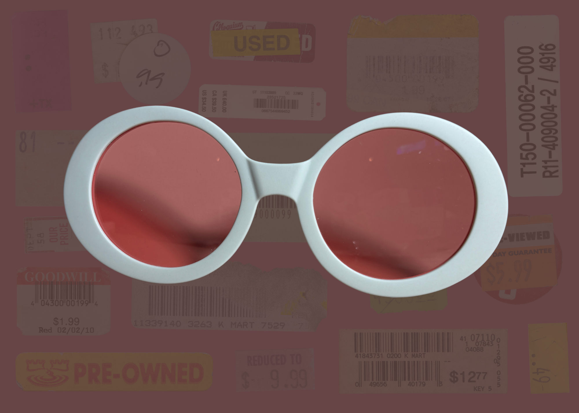 Round retro sunglasses with red lenses and white frame on a background of used books and papers
