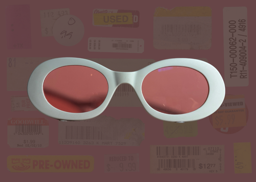 White oval sunglasses with red lenses on a background with various labels and text.