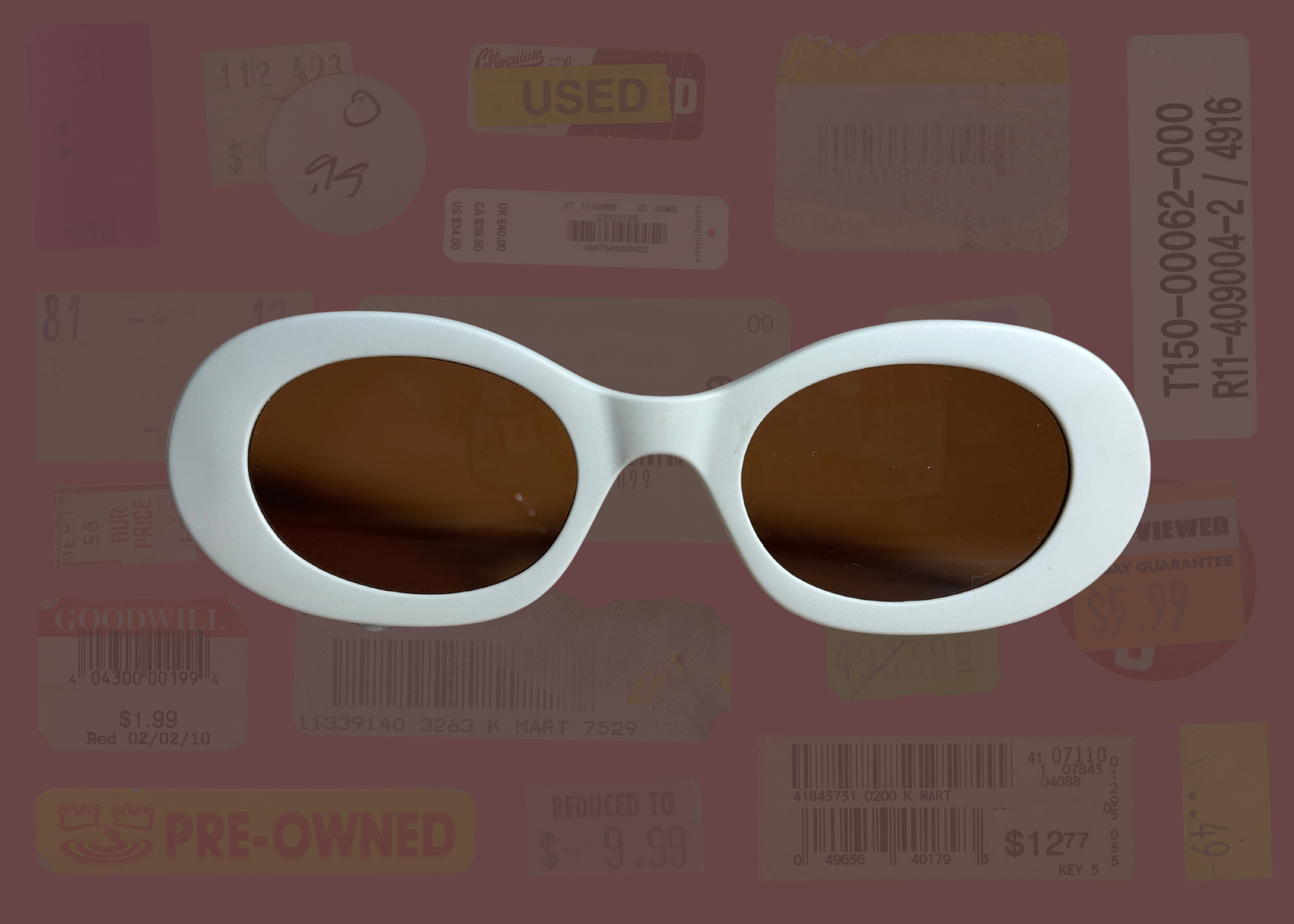 White oval sunglasses with brown lenses on a blurred background with various text and logos.